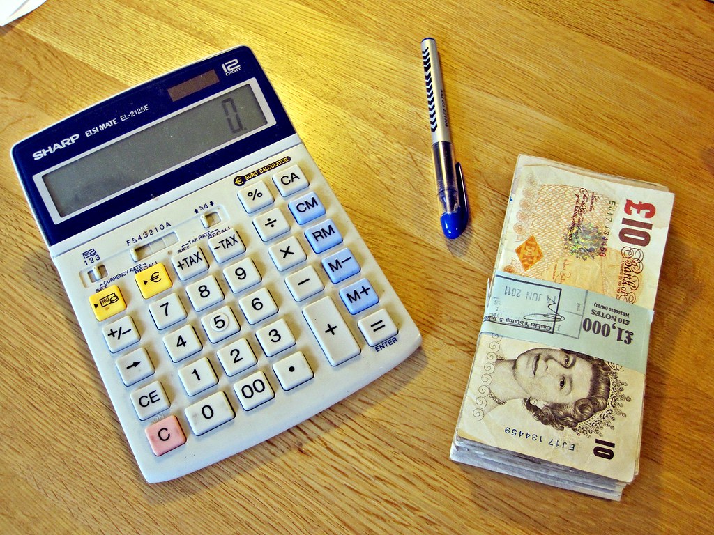 Bureau avec ordinateur, carnet et calculatrice pour estimer le budget d un projet web